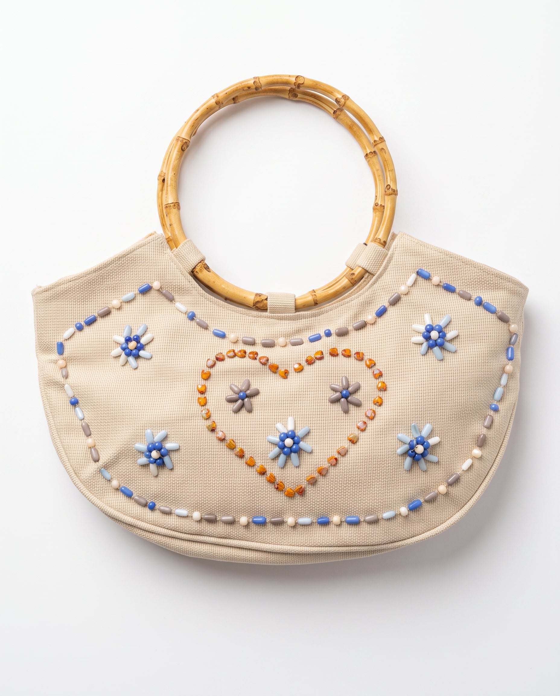 Imagen 1: Bolso vintage color crema con asas de bambú y decoración de cuentas en forma de flores y corazón.