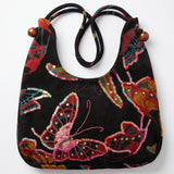 Bolso vintage negro con estampado de mariposas y detalles de lentejuelas de colores.