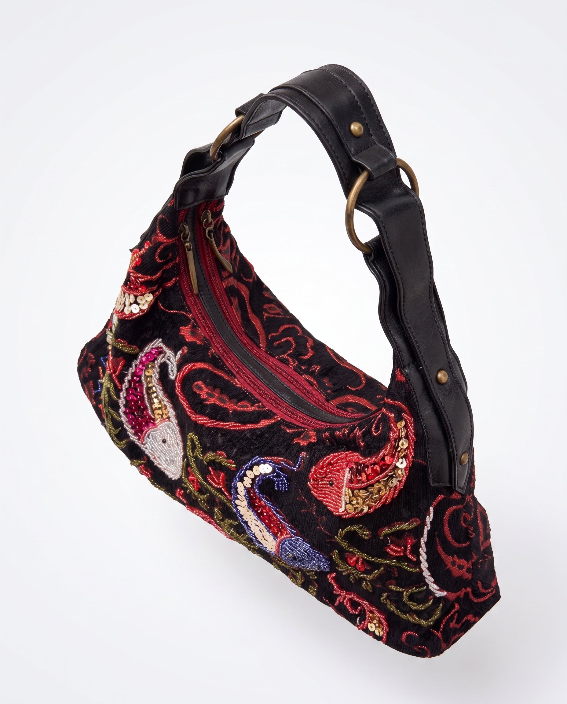Vista lateral del bolso vintage negro con asa regulable y detalles bordados.