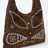 Imagen 2: Vista lateral del bolso vintage marrón con decoración de pedrería y bordados.