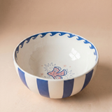 Bowl de cerámica con rayas azules y blancas y dibujo de una paloma en el interior.
