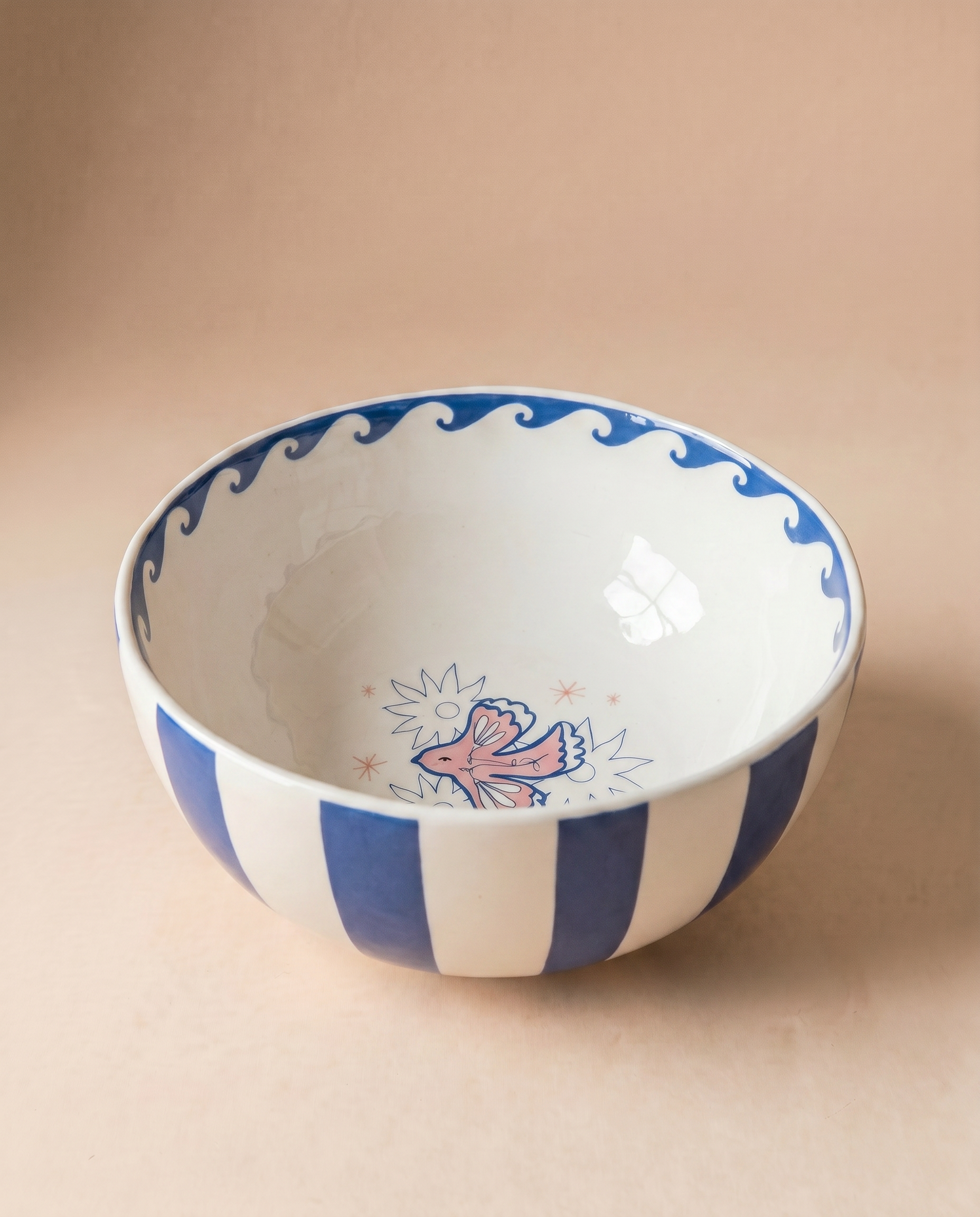 Bowl de cerámica con rayas azules y blancas y dibujo de una paloma en el interior.