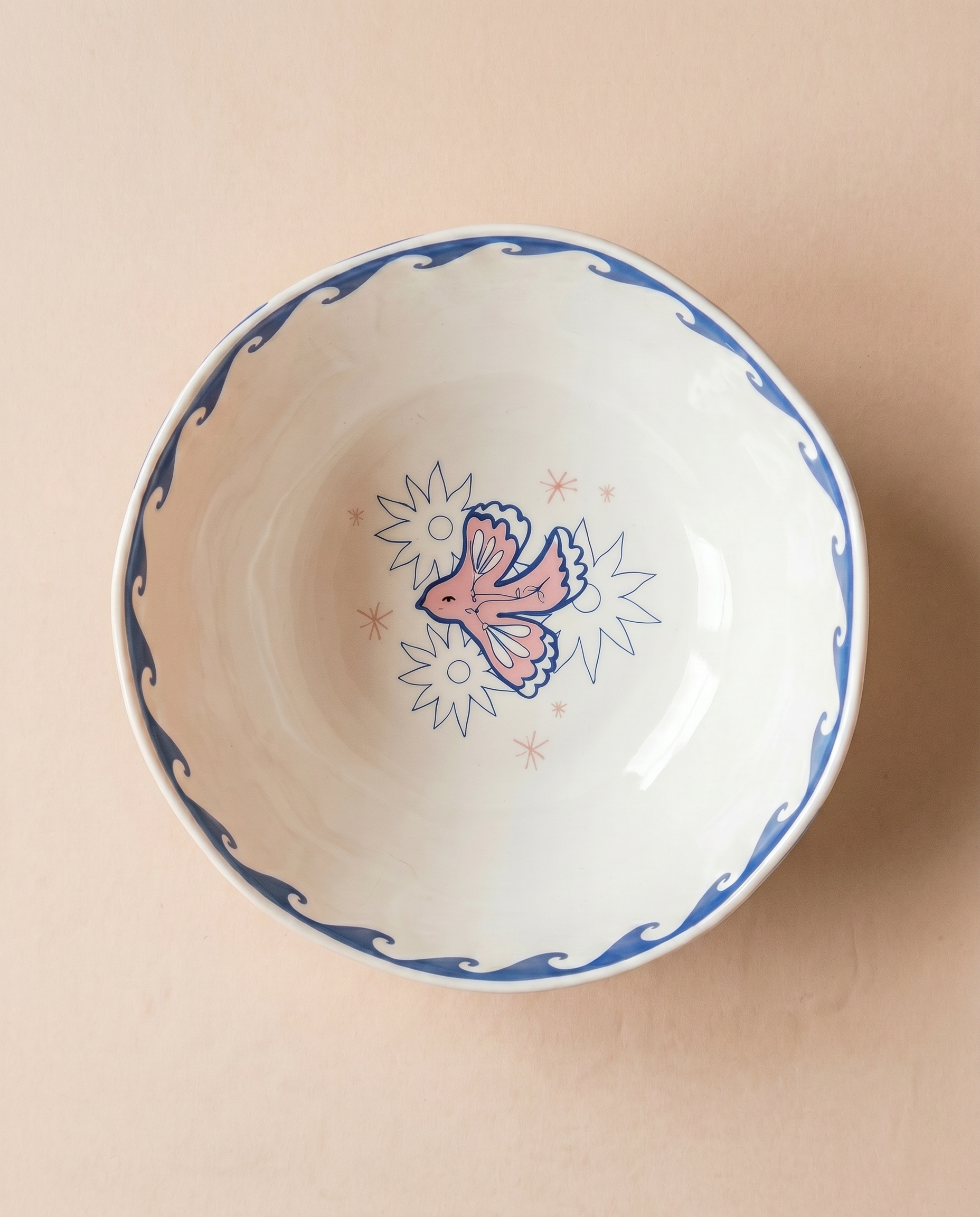 Vista superior del bowl de cerámica con ilustración de una paloma en el fondo.