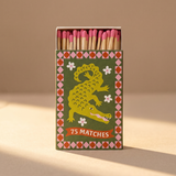 Caja de cerillas largas A Dopo con ilustración de un cocodrilo sobre fondo verde.