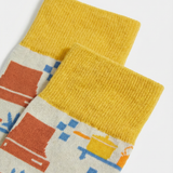 Detalle del tejido de calcetines con utensilios de cocina y costuras planas