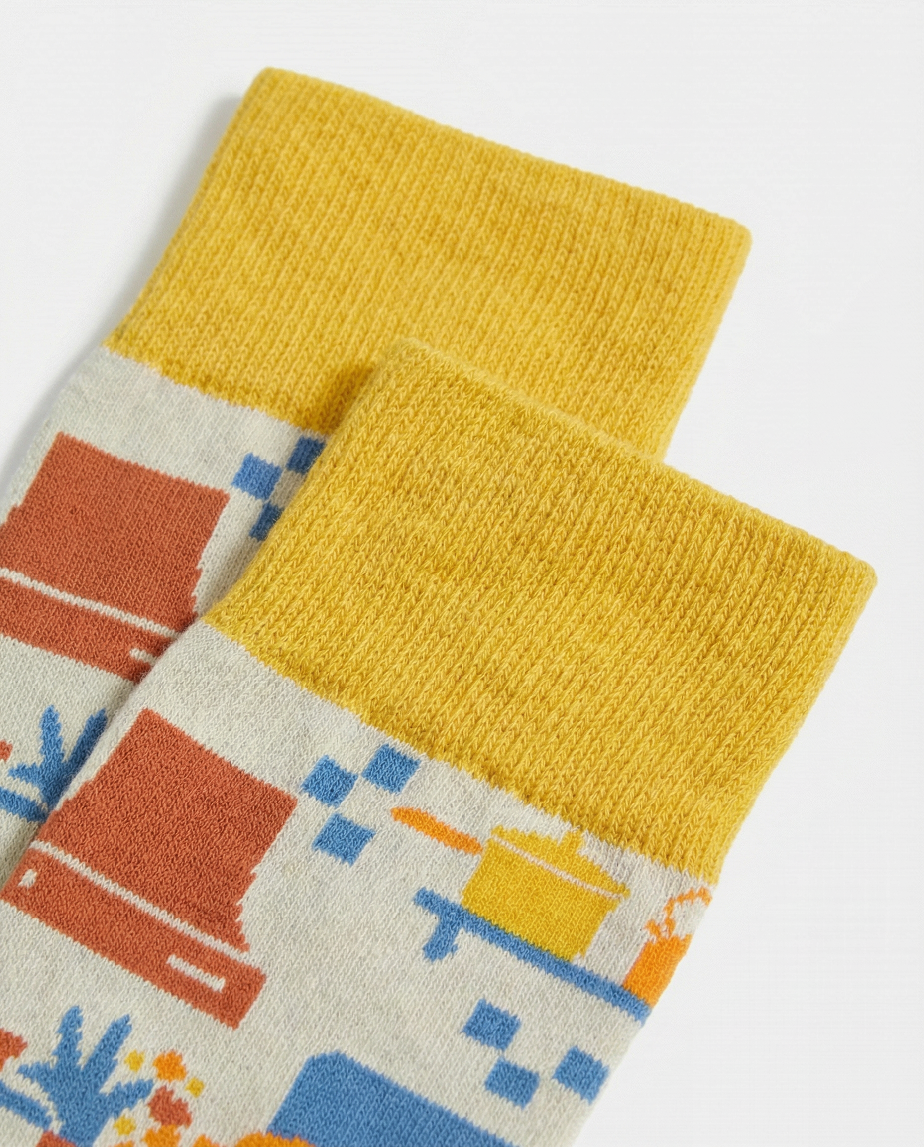 Detalle del tejido de calcetines con utensilios de cocina y costuras planas