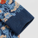 Detalle del tejido de calcetines florales con pájaros y costuras planas