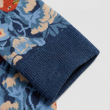 Detalle del tejido de calcetines florales con pájaros y costuras planas