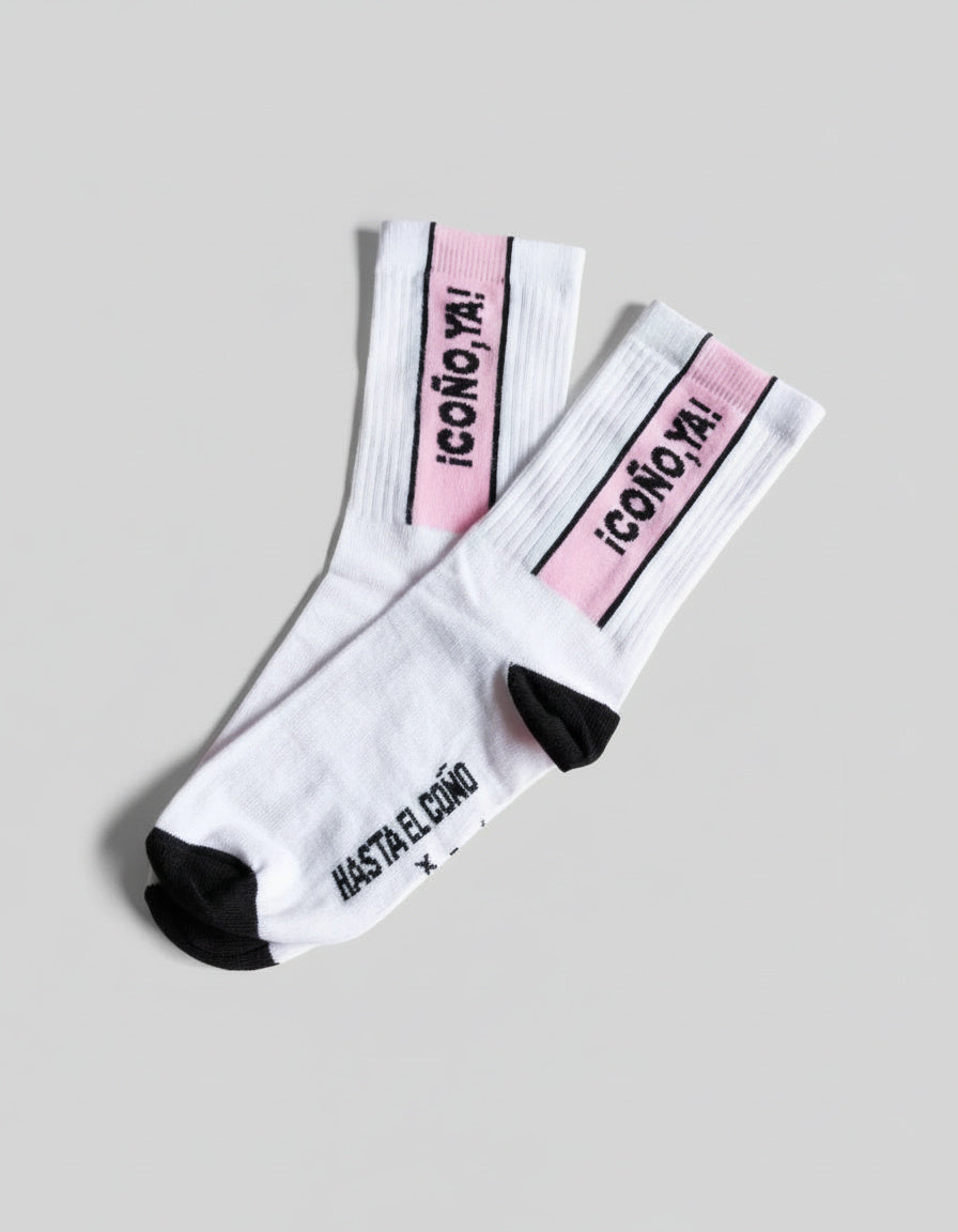 Calcetines divertidos blancos y rosas puestos, mensaje “Coño ya!” visible
