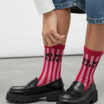 Calcetines deportivos rosa con rayas y frase “No me rayes", vista en modelo