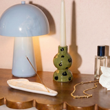 Candelabro de cerámica con estampado animal print verde y negro.