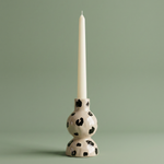 Candelabro de cerámica con estampado animal print blanco y negro.