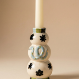 Candelabro de cerámica con diseño de serpiente azul y detalles florales.