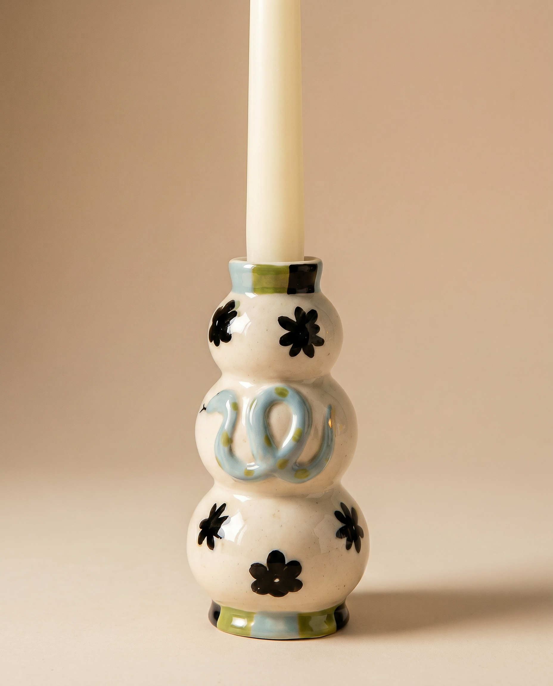 Candelabro de cerámica con diseño de serpiente azul y detalles florales.