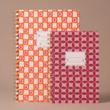 Libretas Orange Check y Pinwheel Pink juntas mostrando sus diseños de portada.
