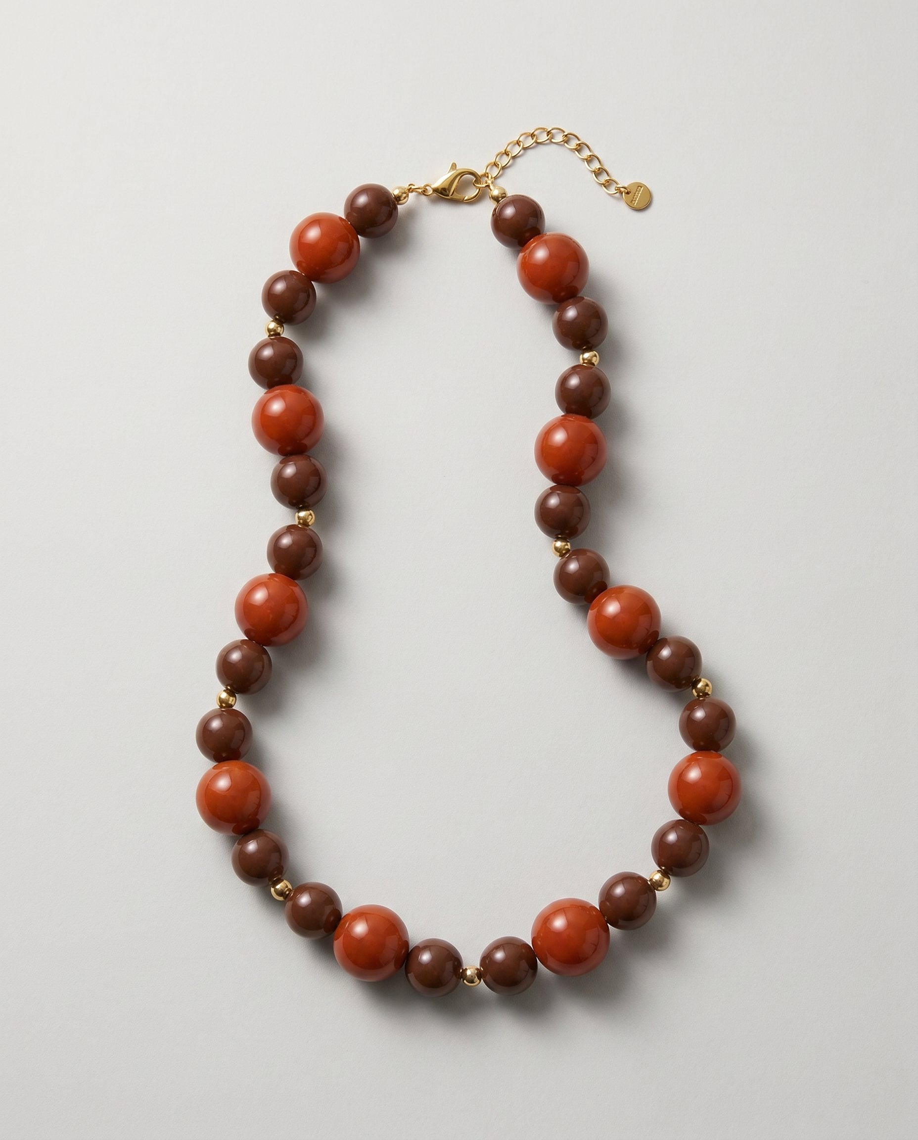 Collar de cuentas acrílicas marrones y terracota con cierre de acero inoxidable.
