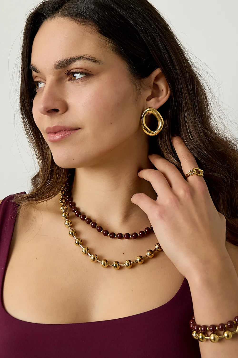 Collar ajustable de doble vuelta con cuentas burdeos y doradas combinado con un look elegante.