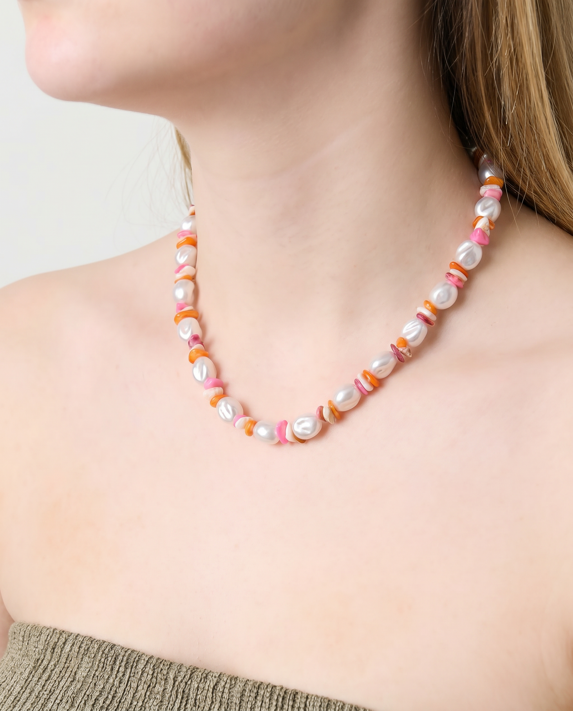 Mujer llevando un collar de perlas con cuentas de colores estilo Y2K.