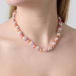 Collar de perlas irregulares con cuentas de colores en tonos rosa, naranja y blanco.