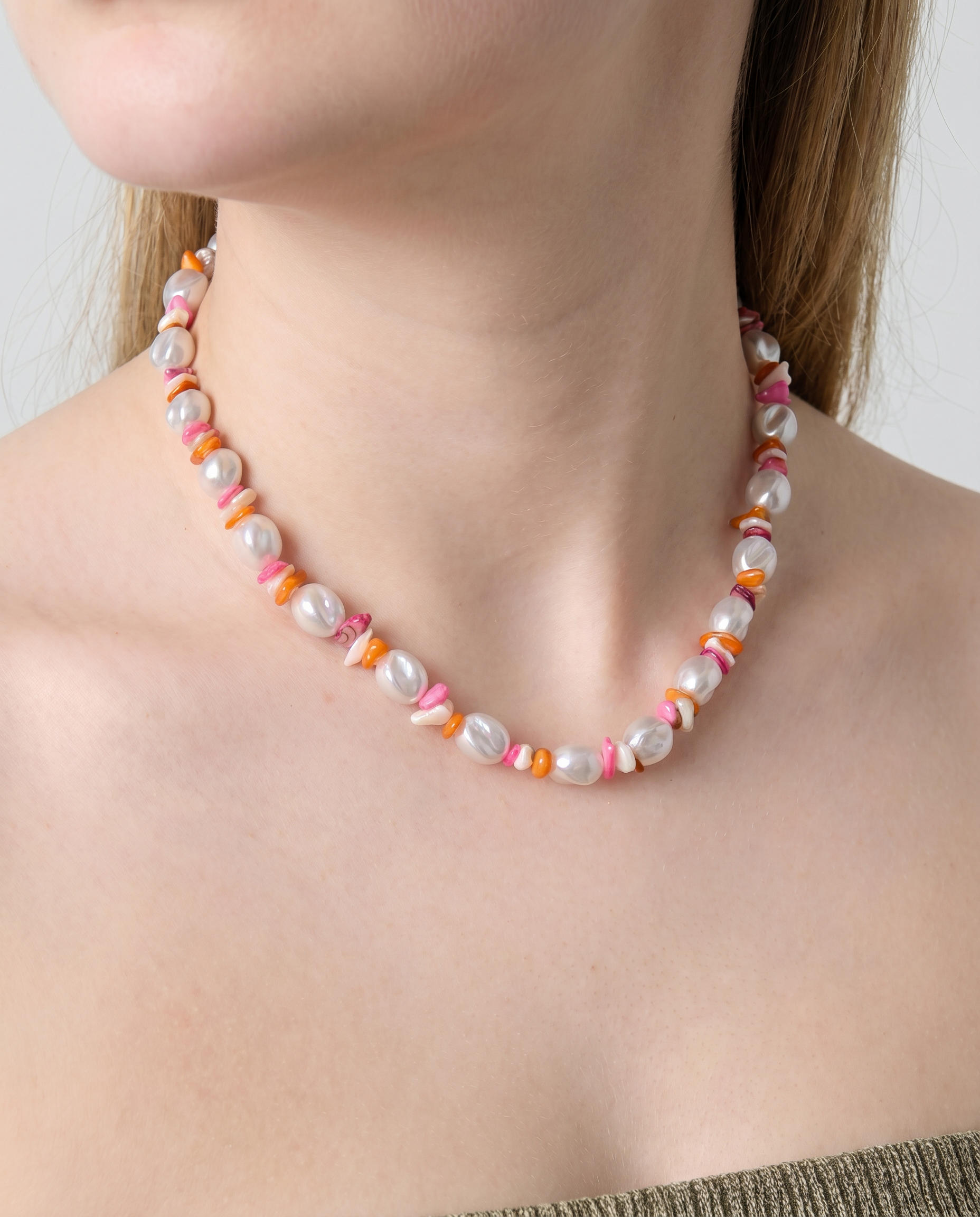 Collar de perlas irregulares con cuentas de colores en tonos rosa, naranja y blanco.