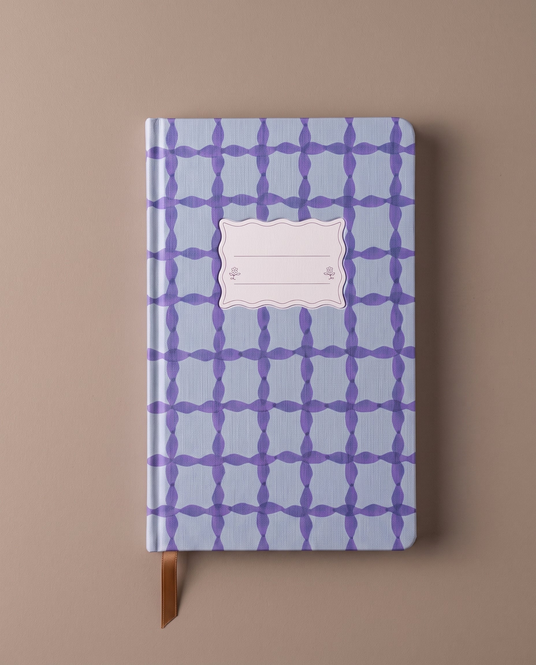 Cuaderno premium de tapa dura con estampado azul y marcapáginas de cinta.