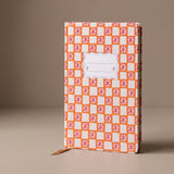 Cuaderno de tapa dura Orange Check Tulip con estampado geométrico en tonos naranja y blanco.