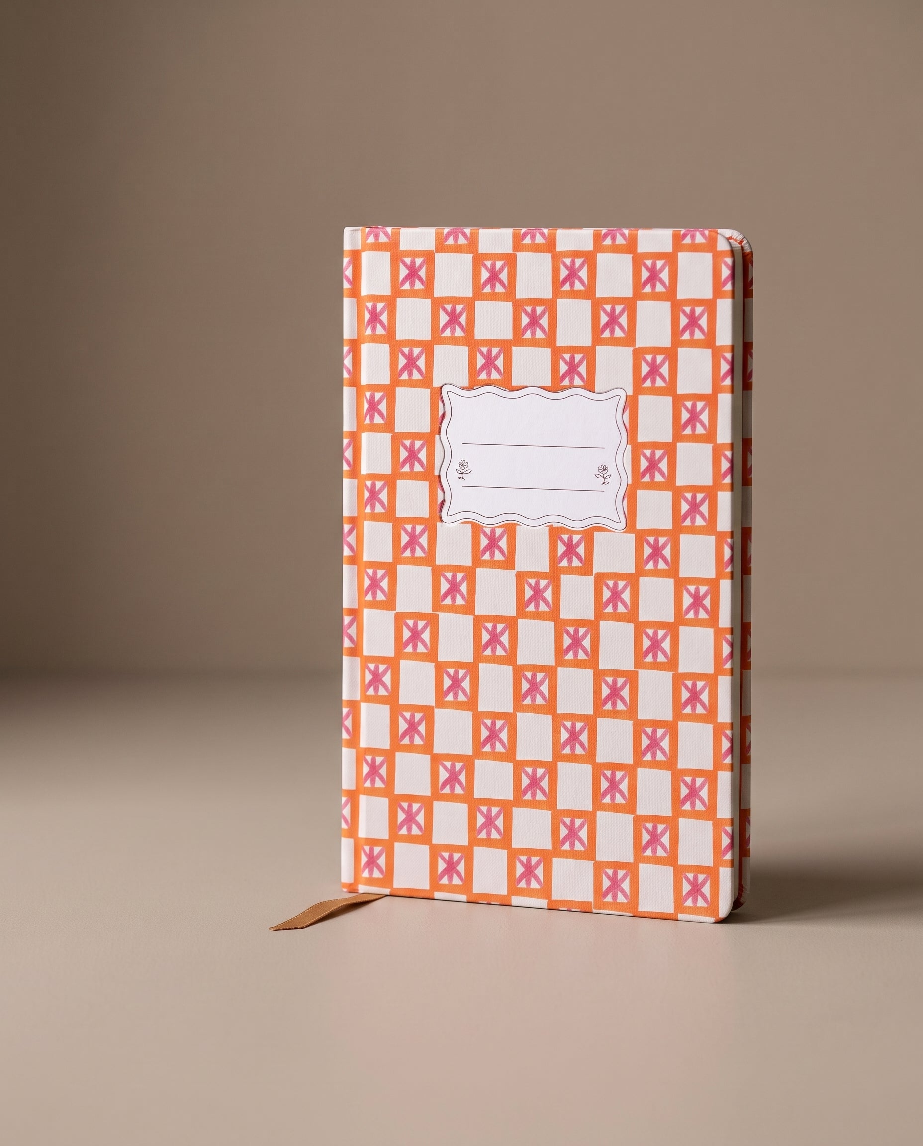 Cuaderno de tapa dura Orange Check Tulip con estampado geométrico en tonos naranja y blanco.