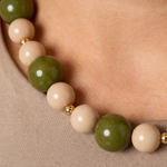 Detalle de las cuentas acrílicas verdes y beige con separadores de acero.