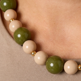 Detalle de las cuentas acrílicas verdes y beige con separadores de acero.