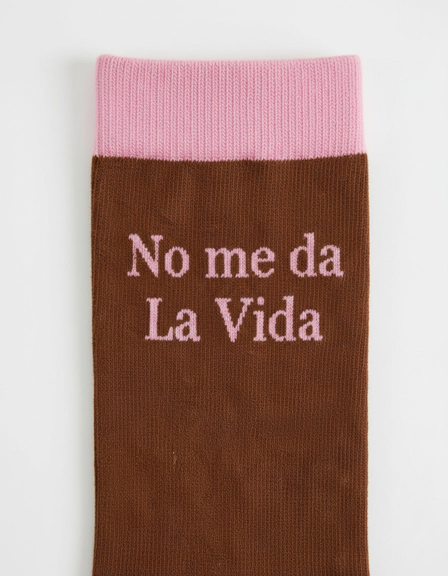 Detalle de la frase bordada “No me da la vida” en calcetines marrón y rosa