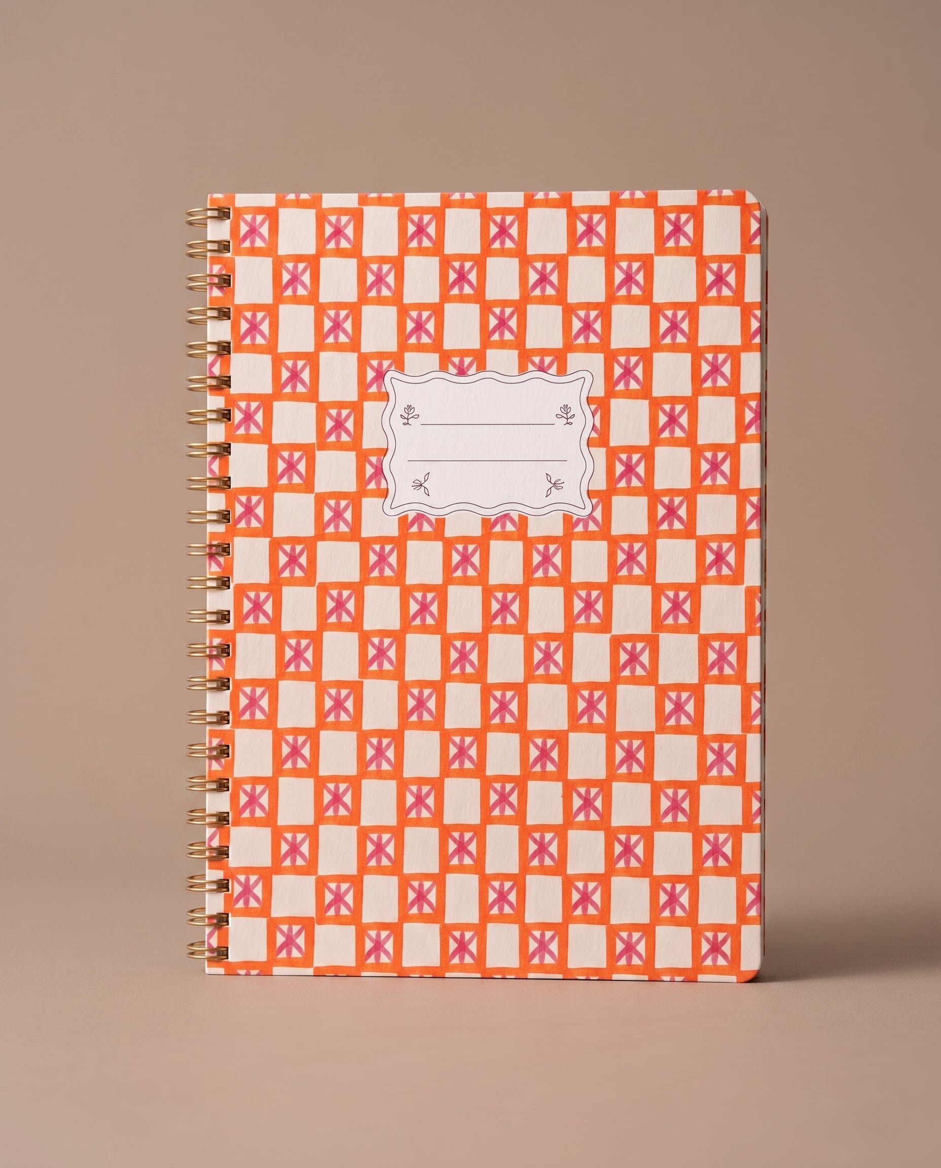 Libreta A4 de espiral Orange Check con estampado geométrico en tonos naranja y blanco.