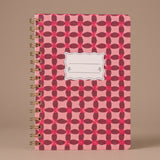 Libreta de espiral Pinwheel Pink con estampado geométrico en tonos rosa y fucsia.