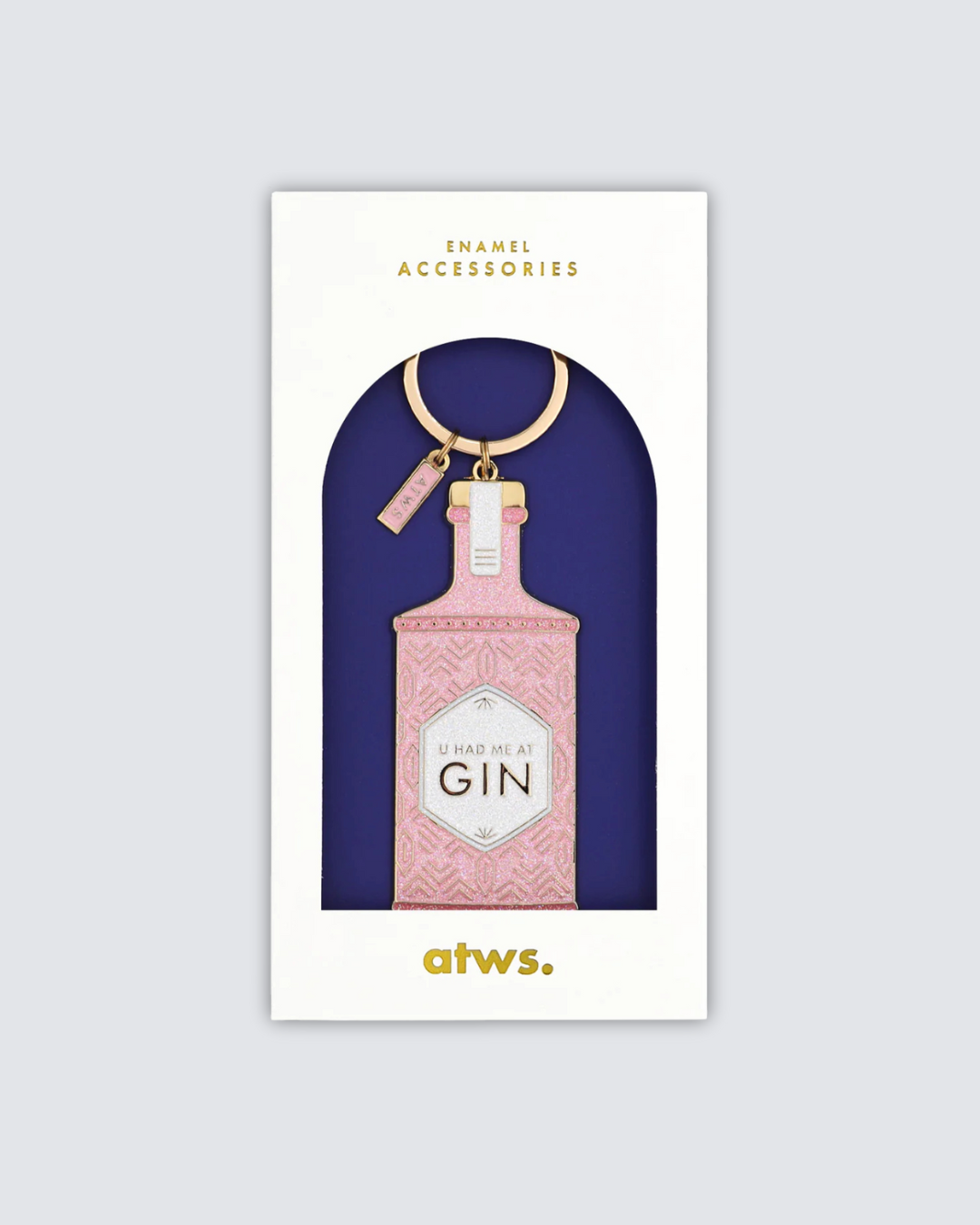 Detalle del llavero metálico chapado en oro con acabado brillante y etiqueta rosa.