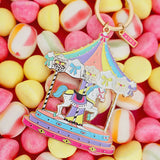 Llavero carrusel pastel de All The Ways To Say sobre fondo de caramelos de colores.