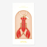 Llavero esmaltado de langosta en rojo con detalles dorados, un accesorio original de All The Ways To Say