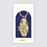 Llavero esmaltado dorado con diseño de hojas verdes y texto Plant Addict Club.