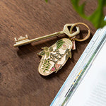 Llavero Plant Addict Club de All The Ways To Say junto a una llave dorada.