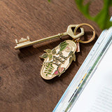 Llavero Plant Addict Club de All The Ways To Say junto a una llave dorada.