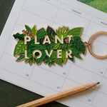 Llavero Plant Lover de All The Ways To Say sobre calendario ilustrado con plantas.