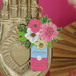 Llavero ramo floral de All The Ways To Say colgado en mano dorada decorativa.