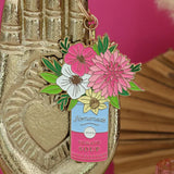 Llavero ramo floral de All The Ways To Say colgado en mano dorada decorativa.