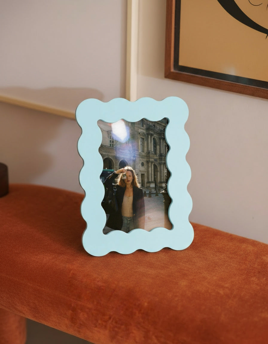 Marco de fotos azul de MDF en una escena decorativa junto a pared y cuadro