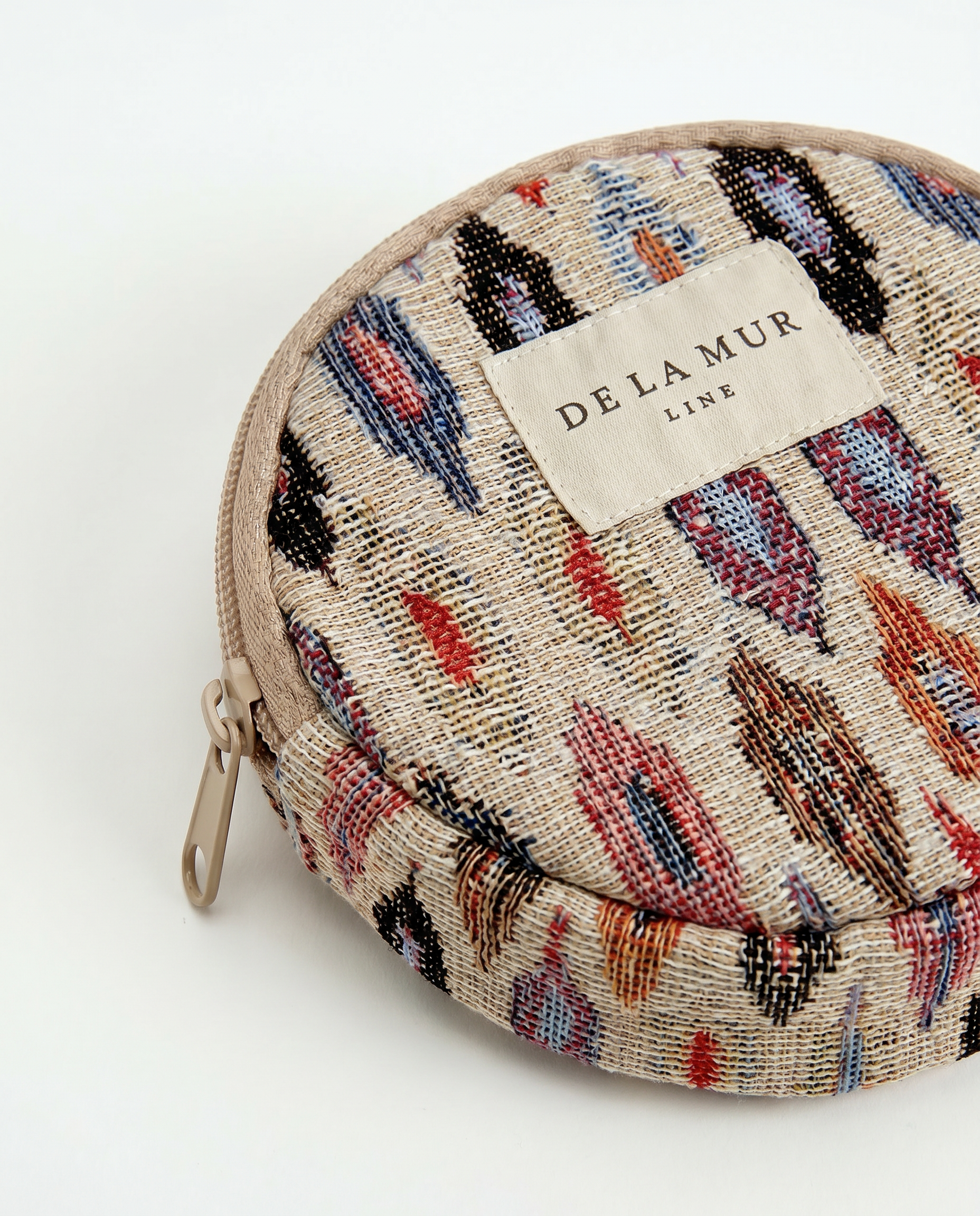 Detalle del monedero de jacquard con estampado étnico en tonos azul, rojo y beige.