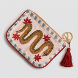 Monedero crema con serpiente dorada bordada, estrellas rojas y borla granate, vista diagonal.