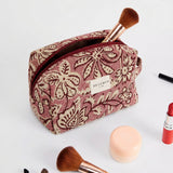 Neceser de jacquard con estampado floral en tonos rosa y granate, vista frontal.