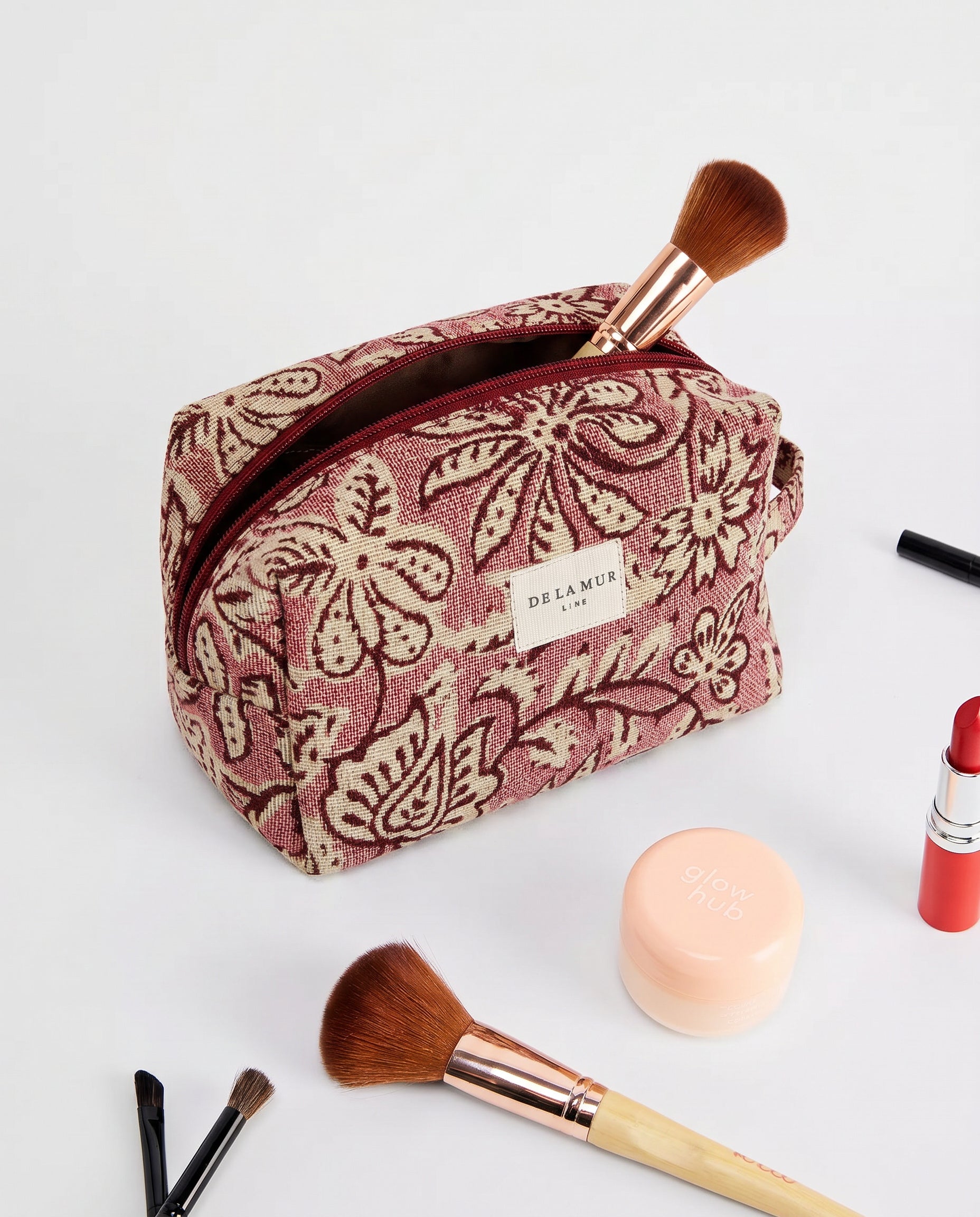 Neceser de jacquard con estampado floral en tonos rosa y granate, vista frontal.