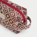 Neceser de jacquard con cremallera superior y estampado geométrico visto en perspectiva.