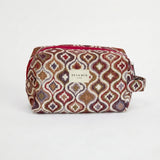 Neceser de jacquard con estampado geométrico en tonos granate, lila, mostaza y beige, vista frontal.