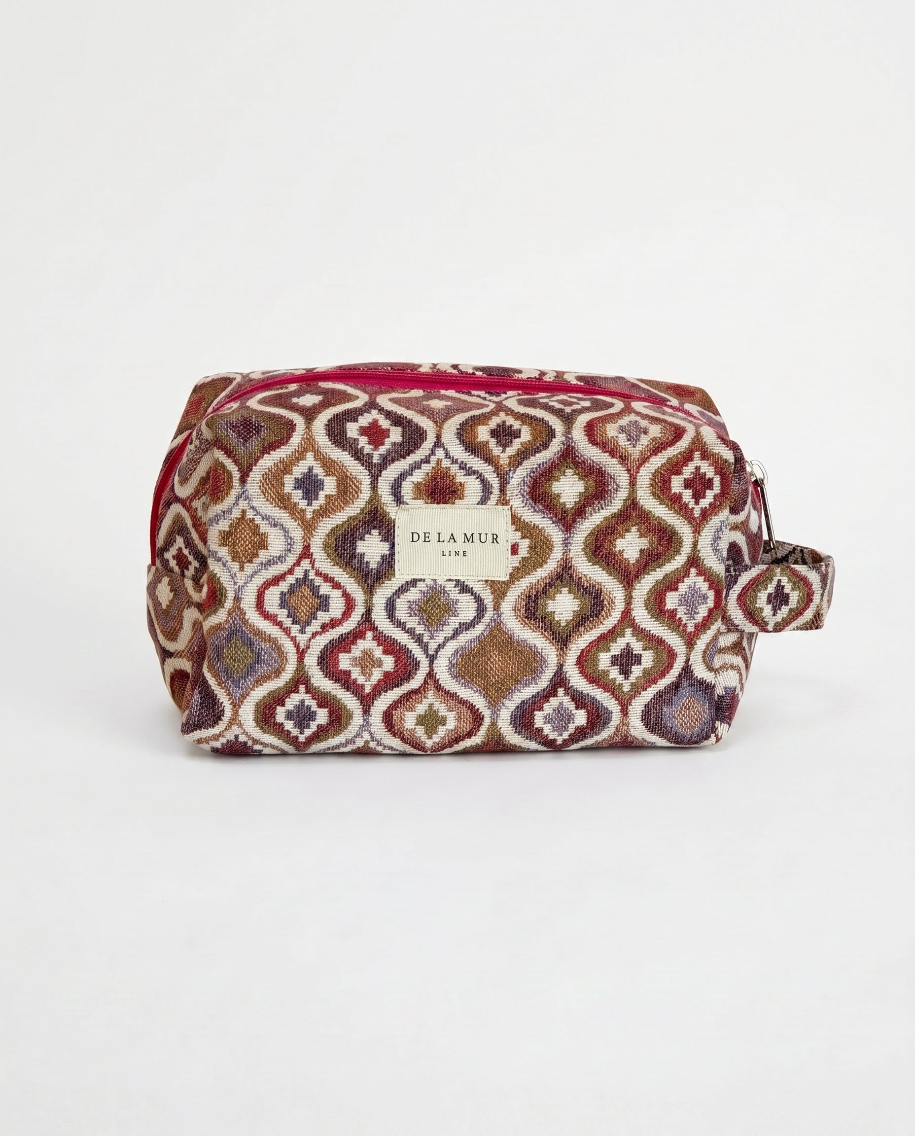 Neceser de jacquard con estampado geométrico en tonos granate, lila, mostaza y beige, vista frontal.