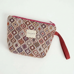 Neceser de jacquard con asa lateral rosa y cierre de cremallera.